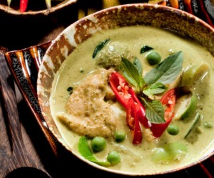 A bowl of traditional Thai green curry served with Thai eggplant and eggplant peas. 